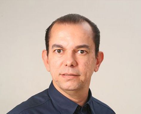 cachorro corgi sentado ao lado de vaso com planta verde