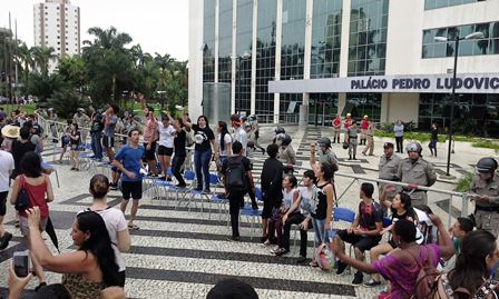Vista do banheiro com banheira, duas pias, espelhos, objetos decorativos e um vaso de planta grande