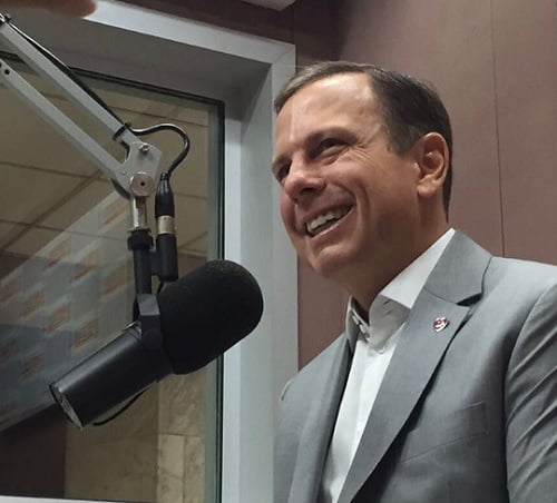 Nhoque com molho vermelho polvilhado com queijo em cima de um prato branco