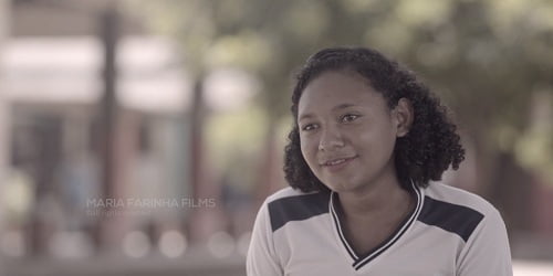 Pessoas sentadas em uma mesa comendo e sorrindo