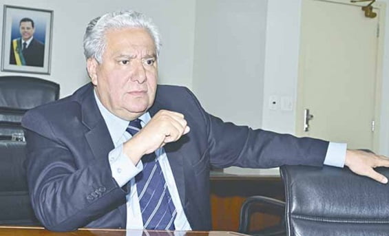 Bolo de cenoura com brigadeiro branco e coco ralado em cima de um prato branco