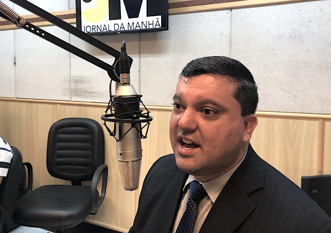 Quarto de bebê com cadeira amarela, berço branco, tapete e decorações muito coloridas.