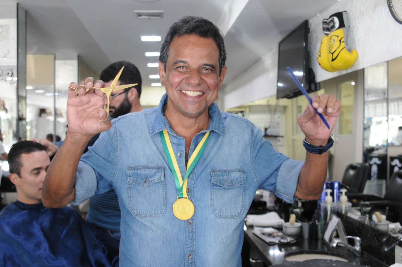Rui exibe a medalha do título da Série B de 2016, do Atlético Goianiense. Presente do seu time de coração. A luva de boxe atrás é uma lembrança de Acelino Freitas, o Popó, tetracampeão mundial (Foto: Domingos Ketelbey)