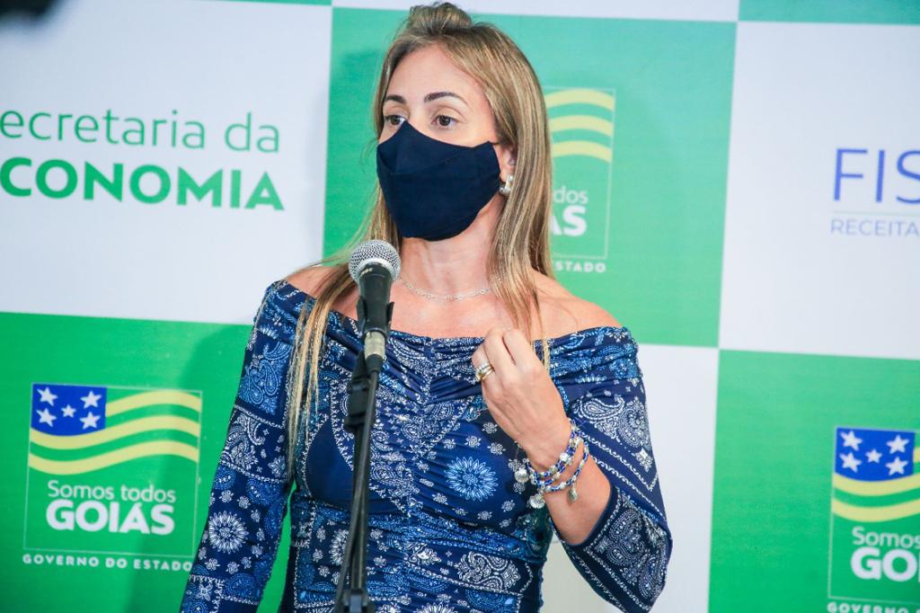Recipiente branco com sorvete de coco em cima de uma mesa de madeira com casca de sorvete e pedaços de coco