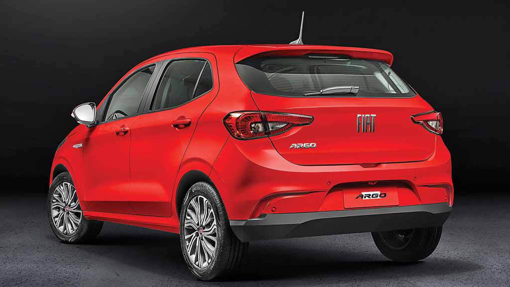 Gato da raça LaPerm com pelagem laranja e encaracolada. Ele está deitado em superfície com pano escuro