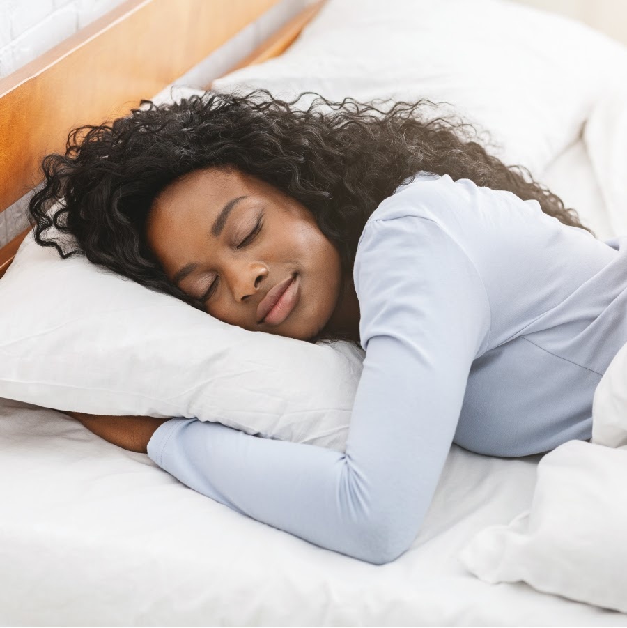 Suco verde em copo de vidro com canudo verde e fatia de abacaxi. Pote verde com espinafre ao fundo