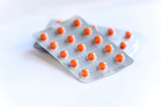 Ilustração do signo de Libra na cor rosa em um fundo azul e laranja