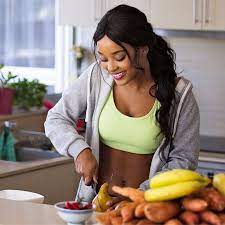 Imagem de um homem com uma fita métrica no pescoço segurando um prato de comida, uma balança, uma maçã e uma garrafa de água em um fundo esverdeado