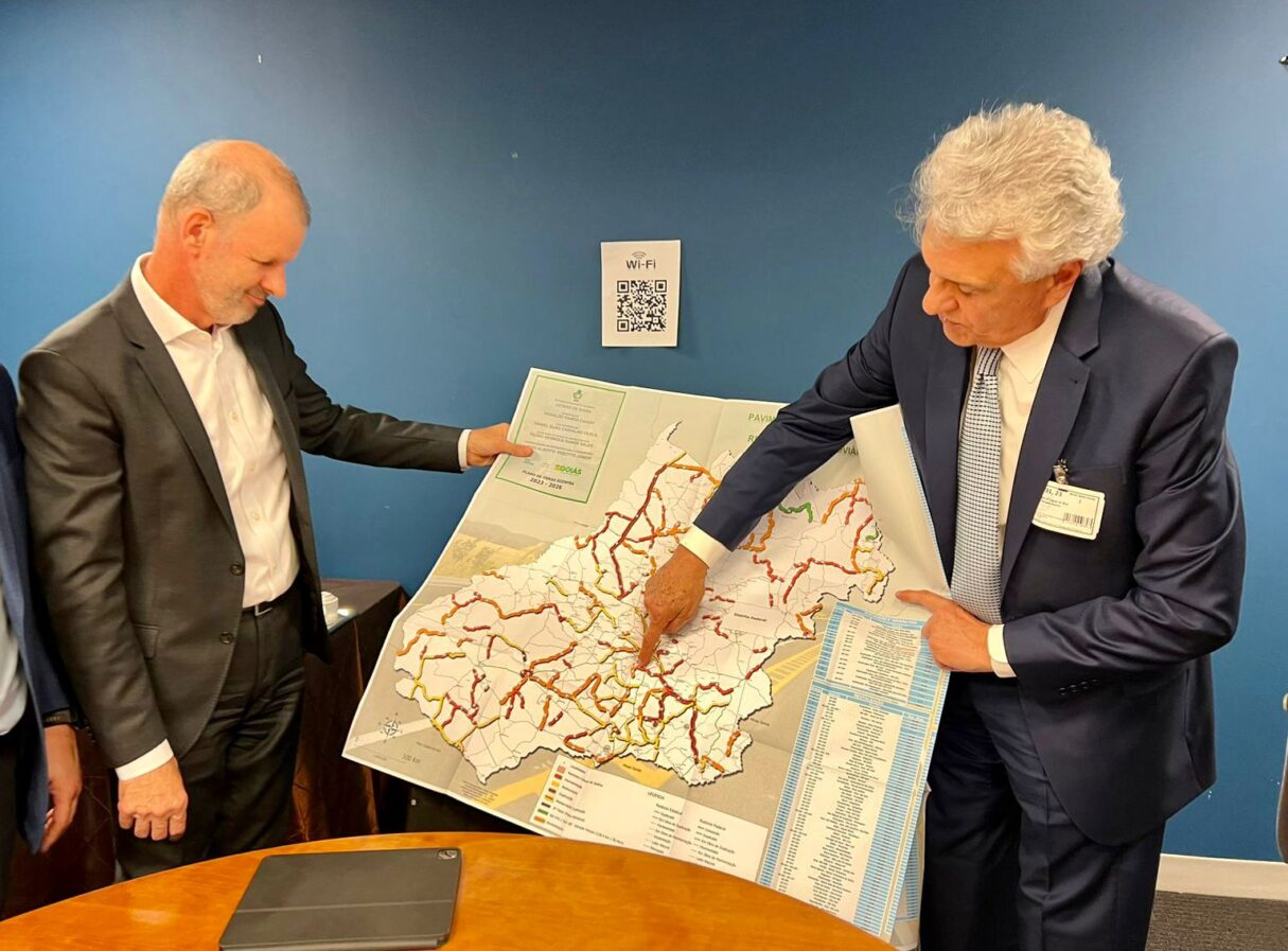 Corredor com instrumentos na parede e outro ambiente com TV e sofá