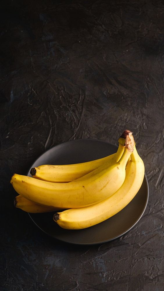 Cão da raça Corgi entre dois potes, um com ração e outro com legumes frescos