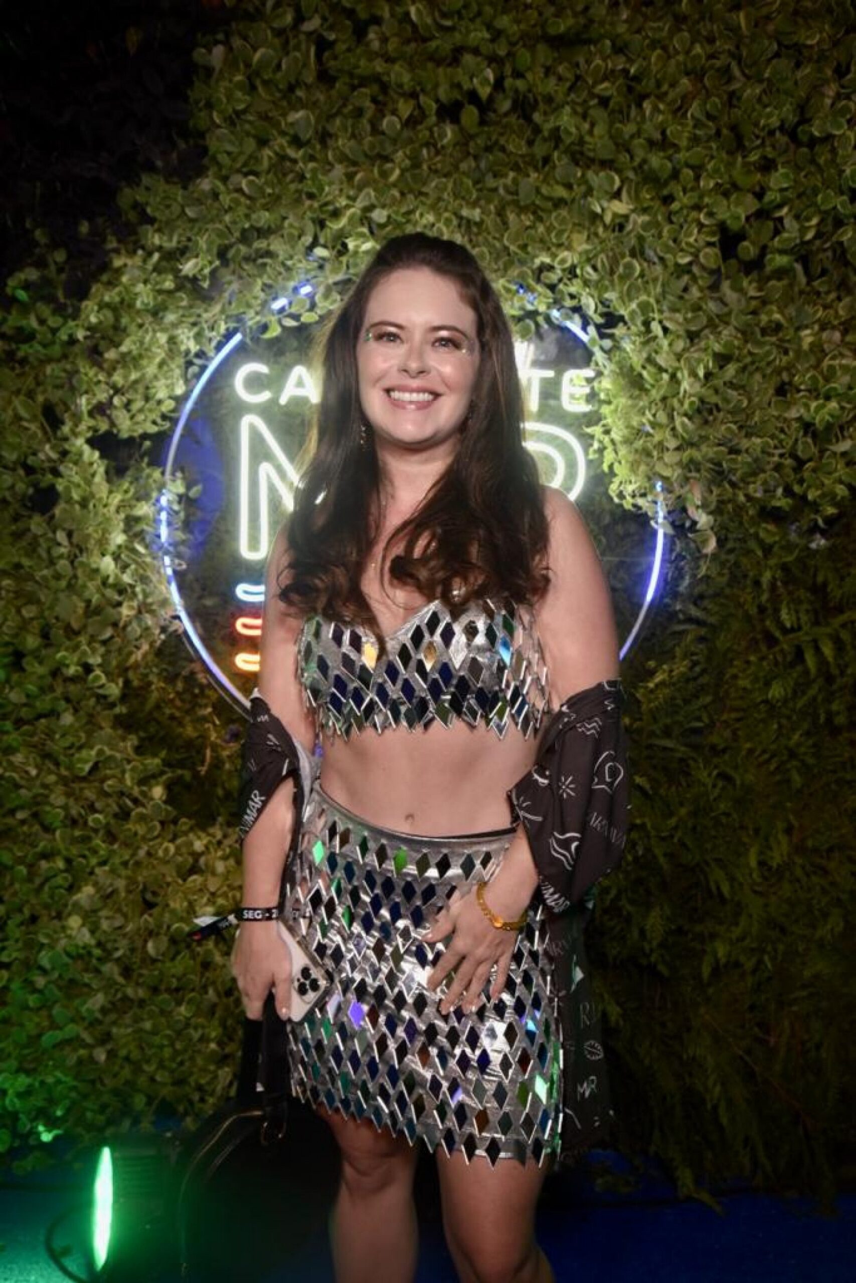 Gato scottish fold marrom-claro, deitado em um sofá com as orelhas baixas e olhando com cabeça de lado 