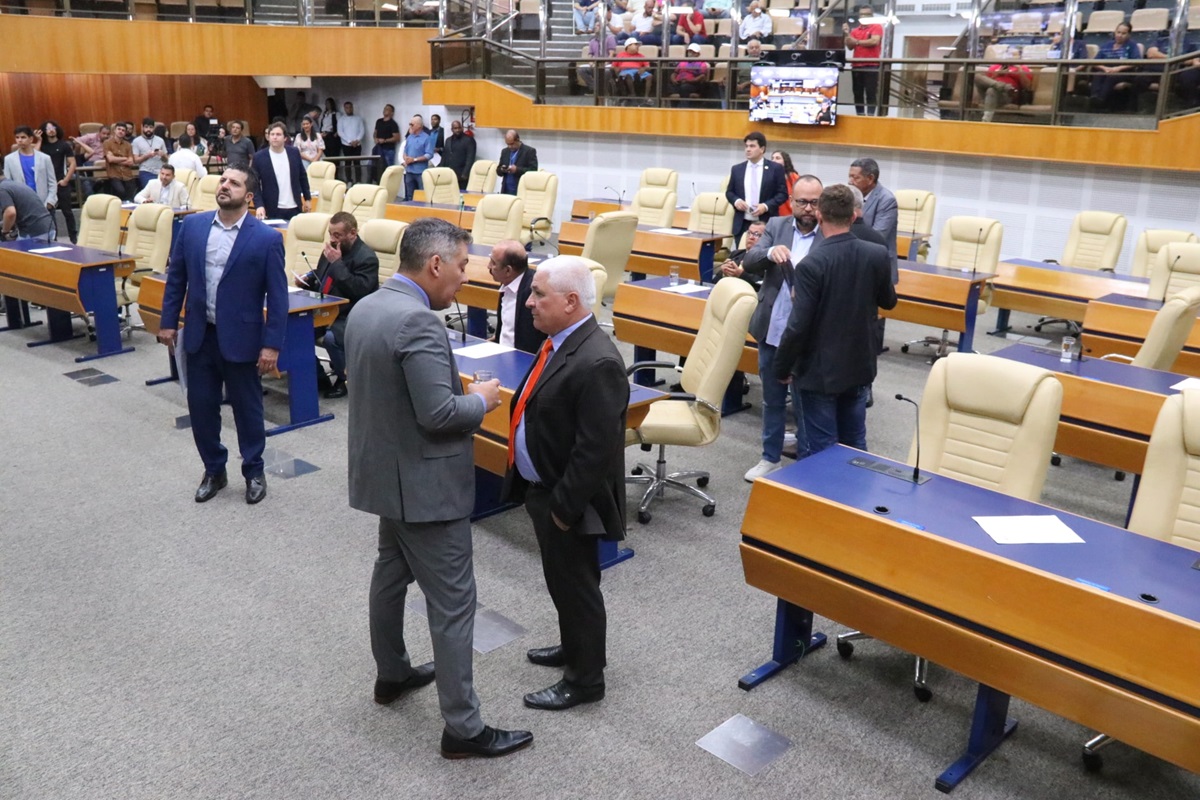 Mulher usando um roupão, sentada em um banheiro e passando creme no cabelo