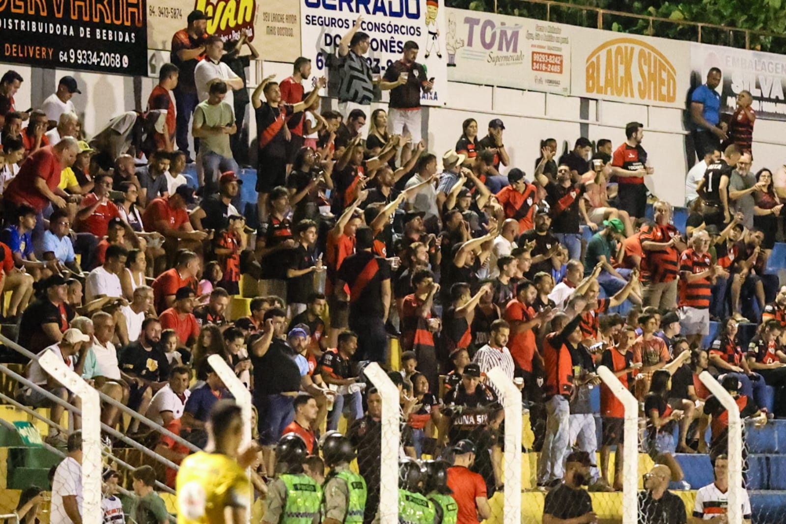 Torta gelada de abacate servida em cima de mesa de madeira. Ao lado um prato branco com um pedaço de torta e um garfo de sobremesa e ao lado também há outro prato branco vazio com um garfo