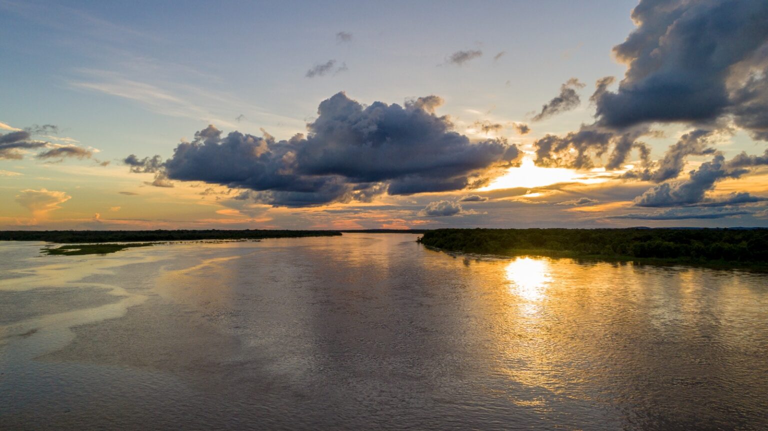 Mulher com maquiagem amarela no rosto e cabelos trançados com enfeites coloridos 