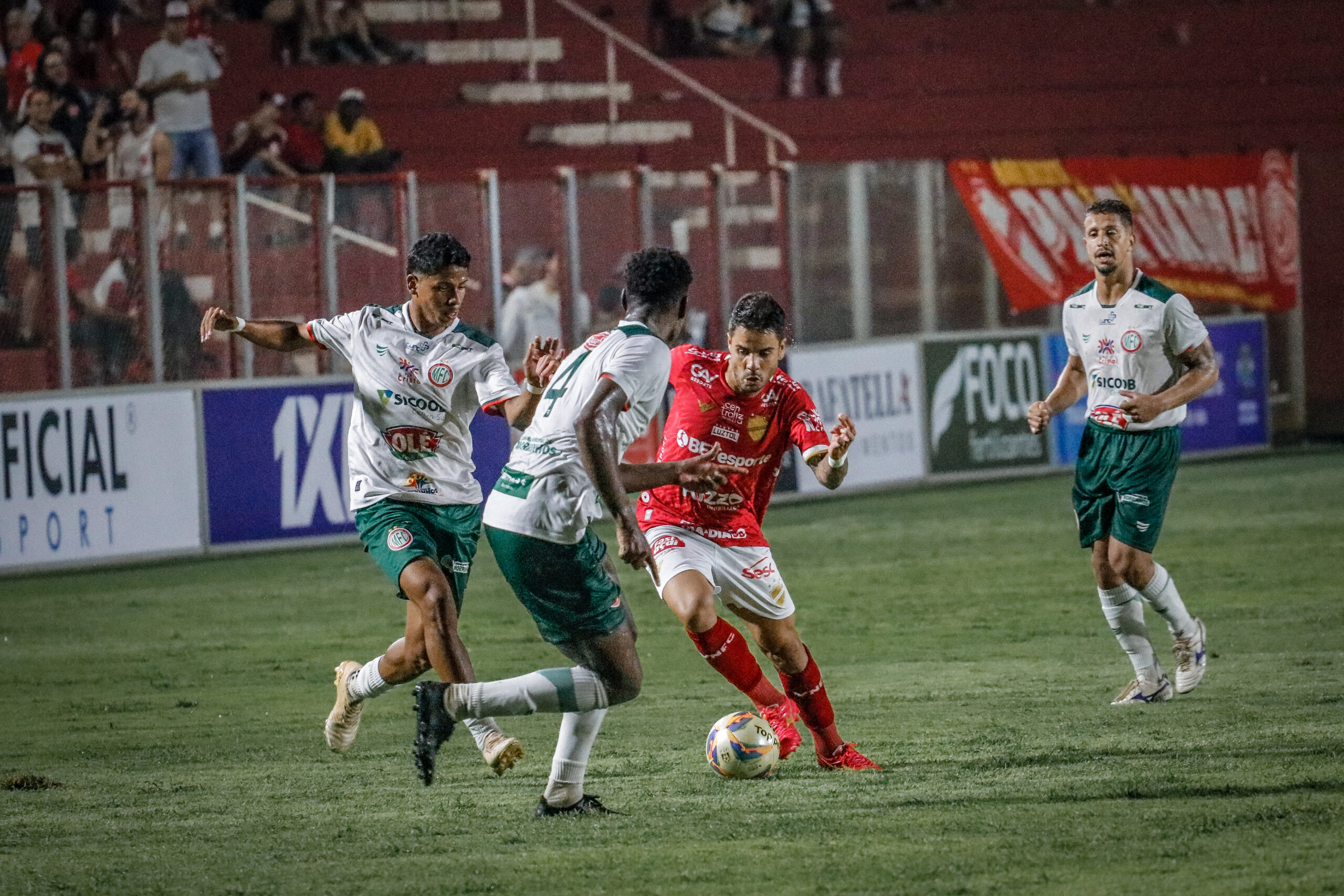 mulher sentada no chão da academia a amarrando cadarço de tênis rosa