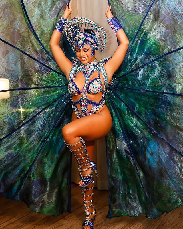 Duas mulheres uma vestida de preto e outra de rosa em uma sala parcialmente escura com uma expressão admirada 