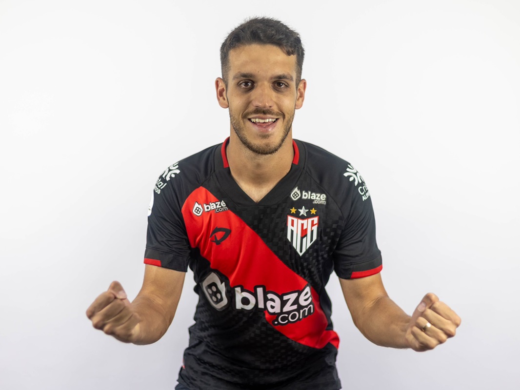 Idosa andando na rua segurando uma sombrinha com uma expressão preocupada