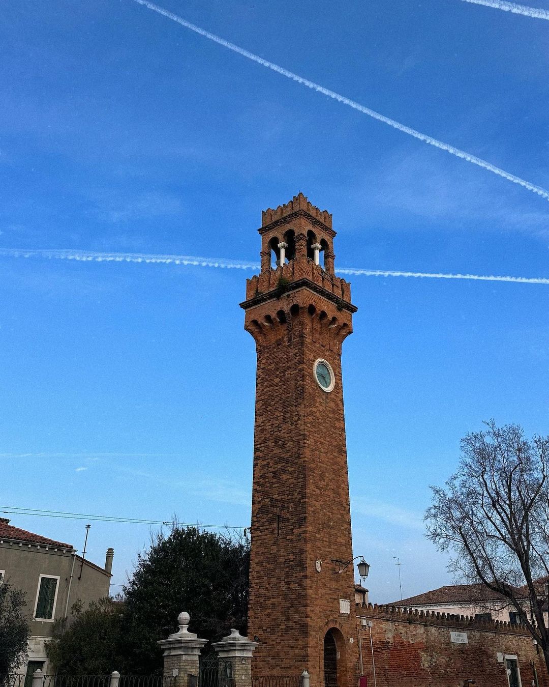 Produtos para cuidados com o cabelo, incluindo frascos de vidro âmbar e uma escova de madeira, dispostos sobre uma superfície de mármore branco