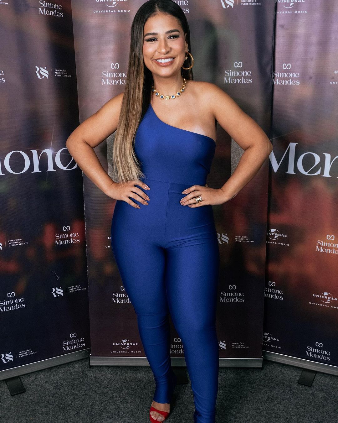 Cão da raça pastor belga groenendael, de pelagem preta e língua para fora, em ambiente verde 