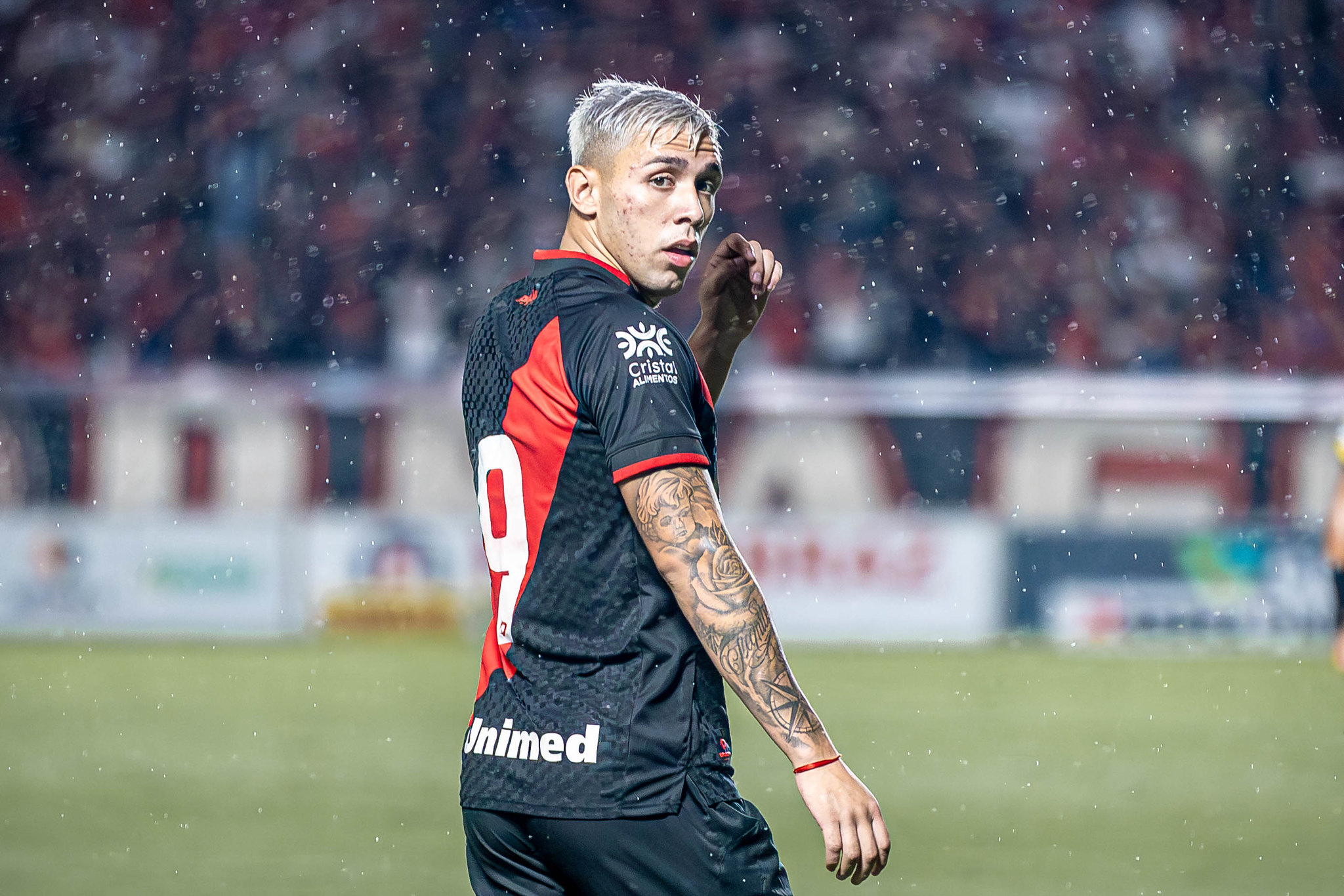 Peito de frango com purê de batata-doce laranja servido em prato preto de cerâmica em cima de bancada cinza de mármore