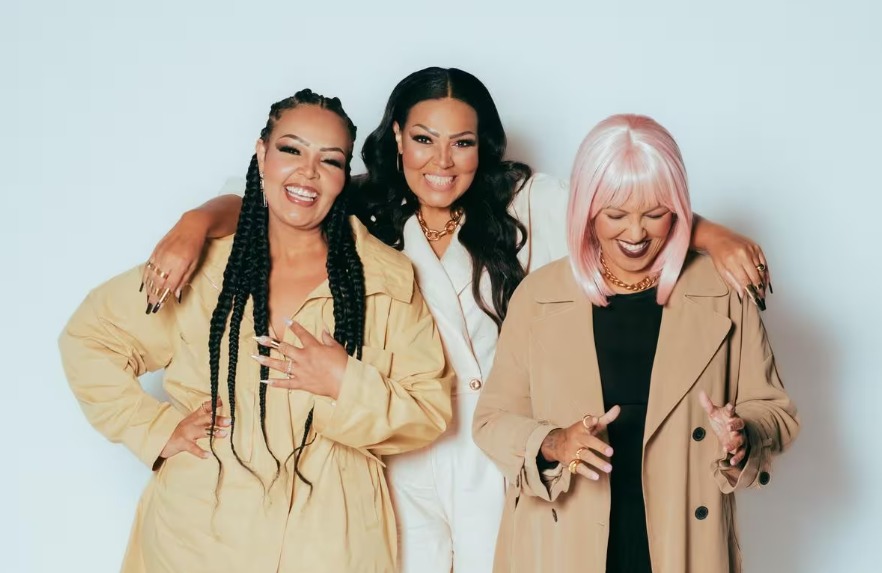 Mulher sentada em frente a uma mesa com notebook alongando os braços 