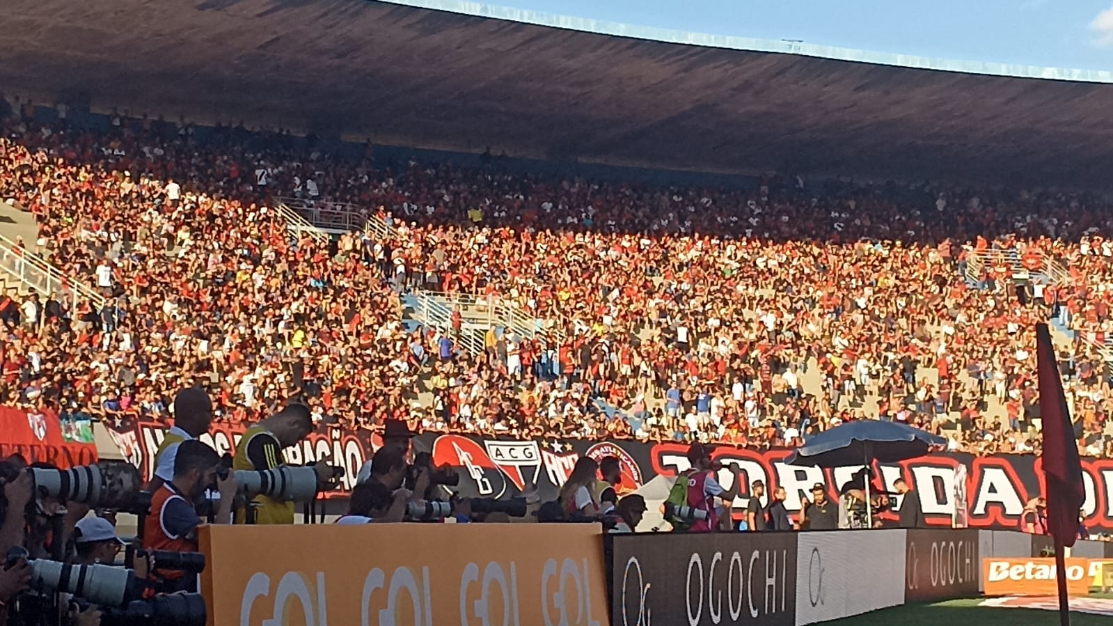 Casal de roupa preta sorrindo e correndo ao ar livre com cidade ao fundo