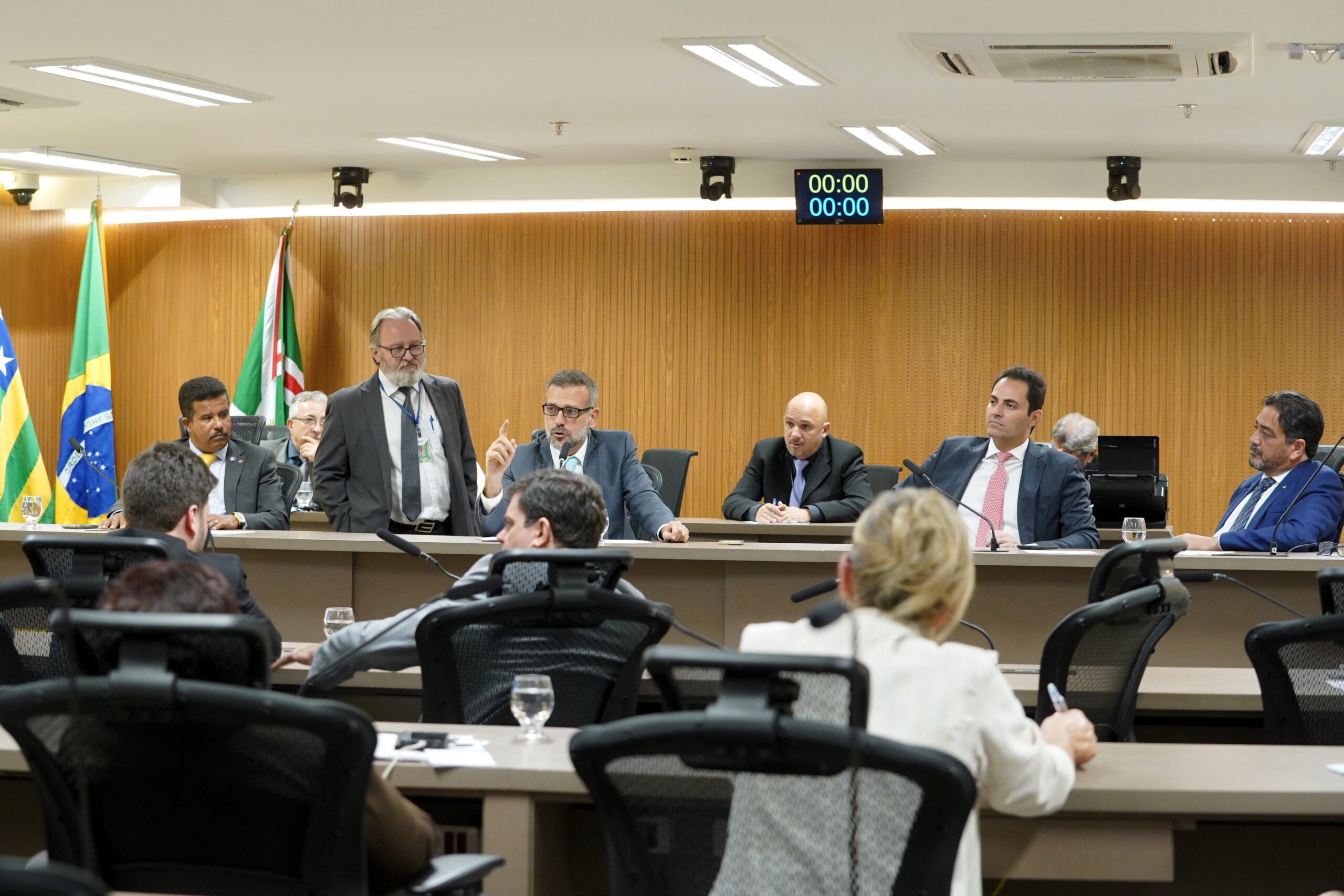 Ilustração do signo Aquário, com símbolo composto por três linhas onduladas horizontais em tons de azul, sobre fundo verde-claro