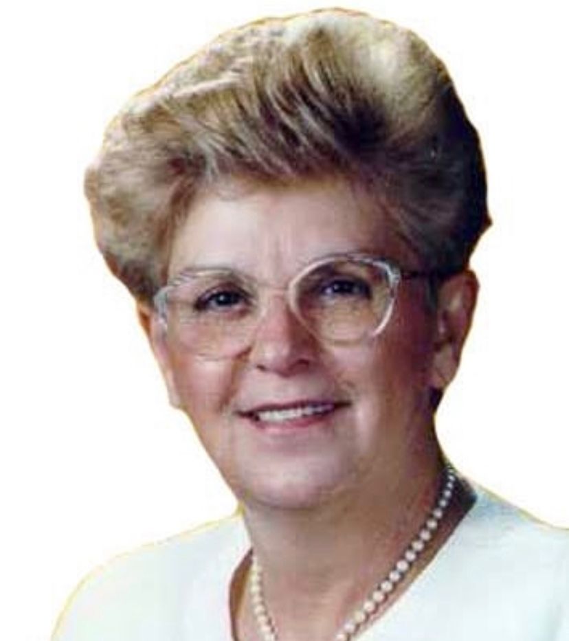 Ilustração do signo de Capricórnio com símbolo vermelho em forma de "n" curvado seguido de um laço, sobre fundo cinza e marrom-escuro