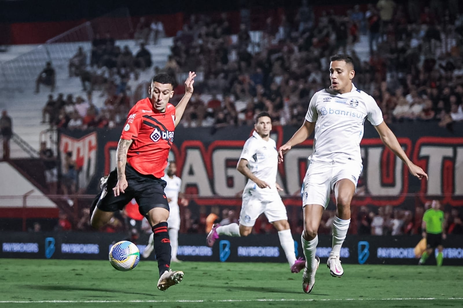 Duas mulheres e um menino deitados em colchonetes fazendo ponte de glúteos 