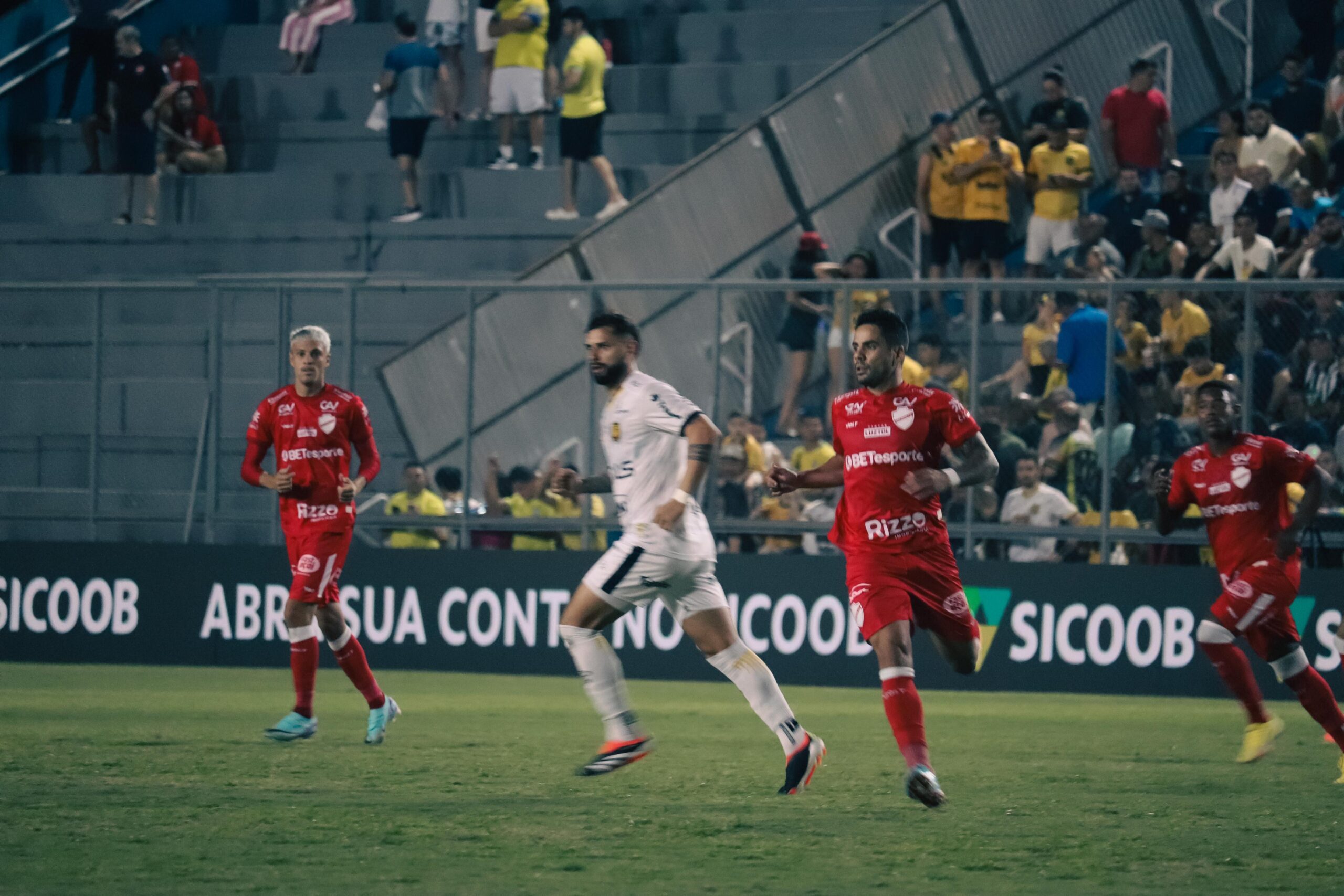 Menino sorrindo, sentado e escrevendo 