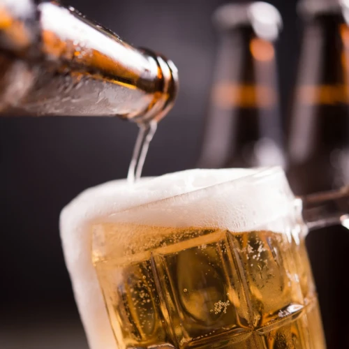 garrafas-de-vidro-de-cerveja-com-vidro-e-gelo-no-fundo-escuro