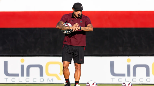 Treinador em Campo com Bolas de Futebol