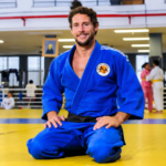 Judoca sorridente no dojo ensolarado