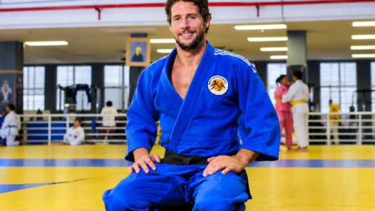 Judoca sorridente no dojo ensolarado